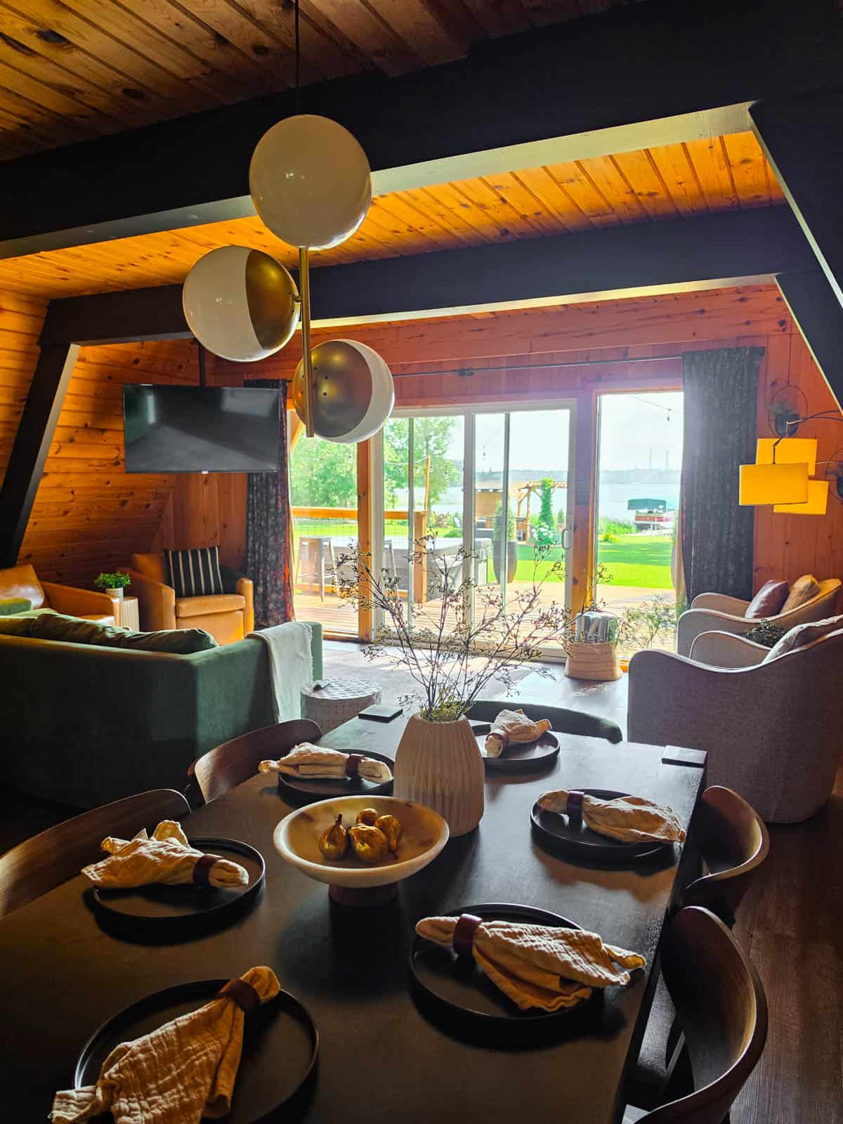 A-frame cabin dining and living area with lake views through large windows
