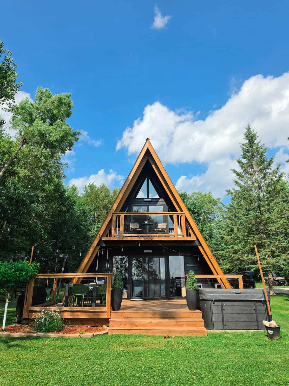 Front exterior of the Bass Lake A-frame cabin with deck and hot tub