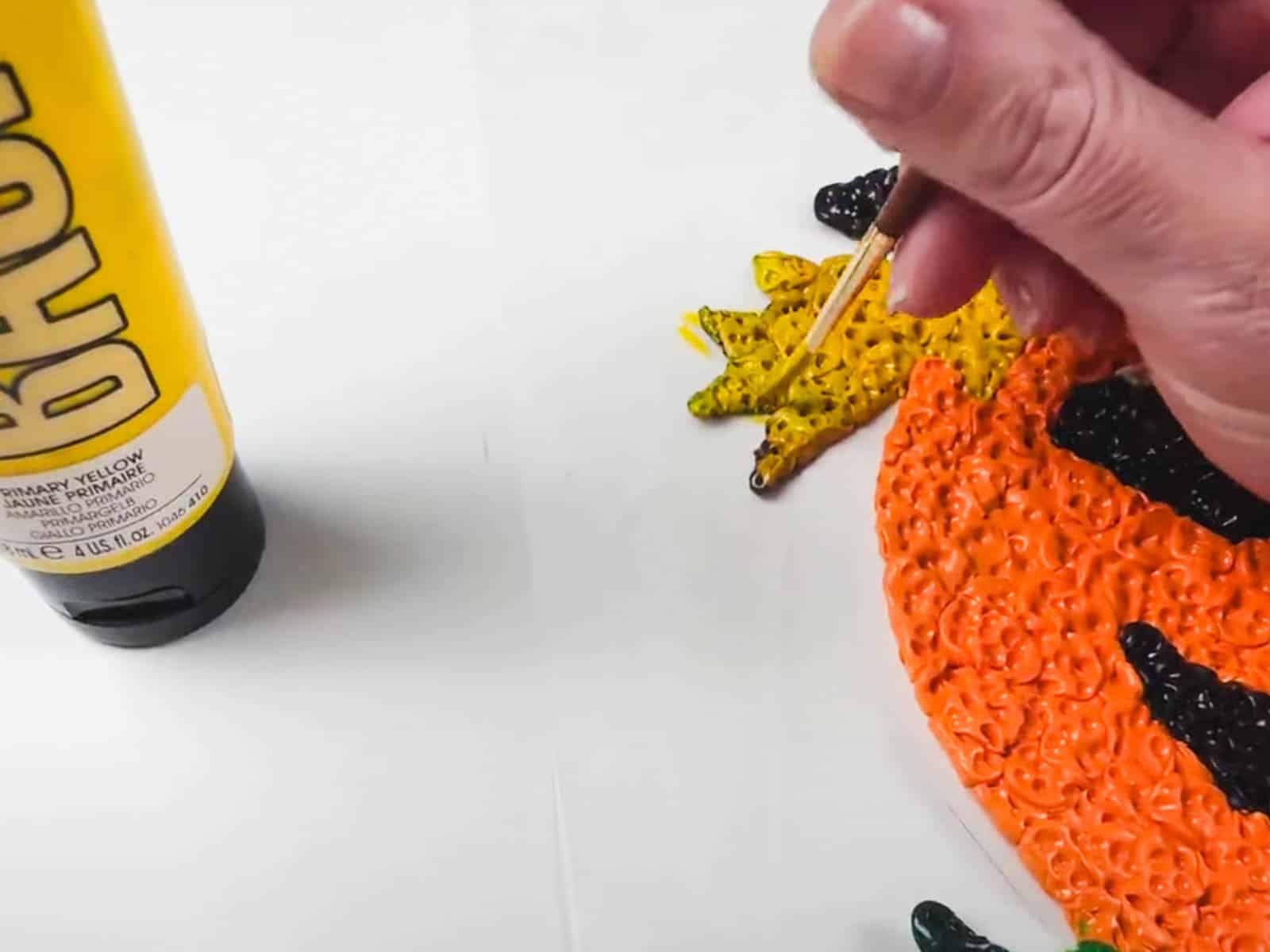 Scorched yellow clay on a handmade Halloween pumpkin decoration after baking