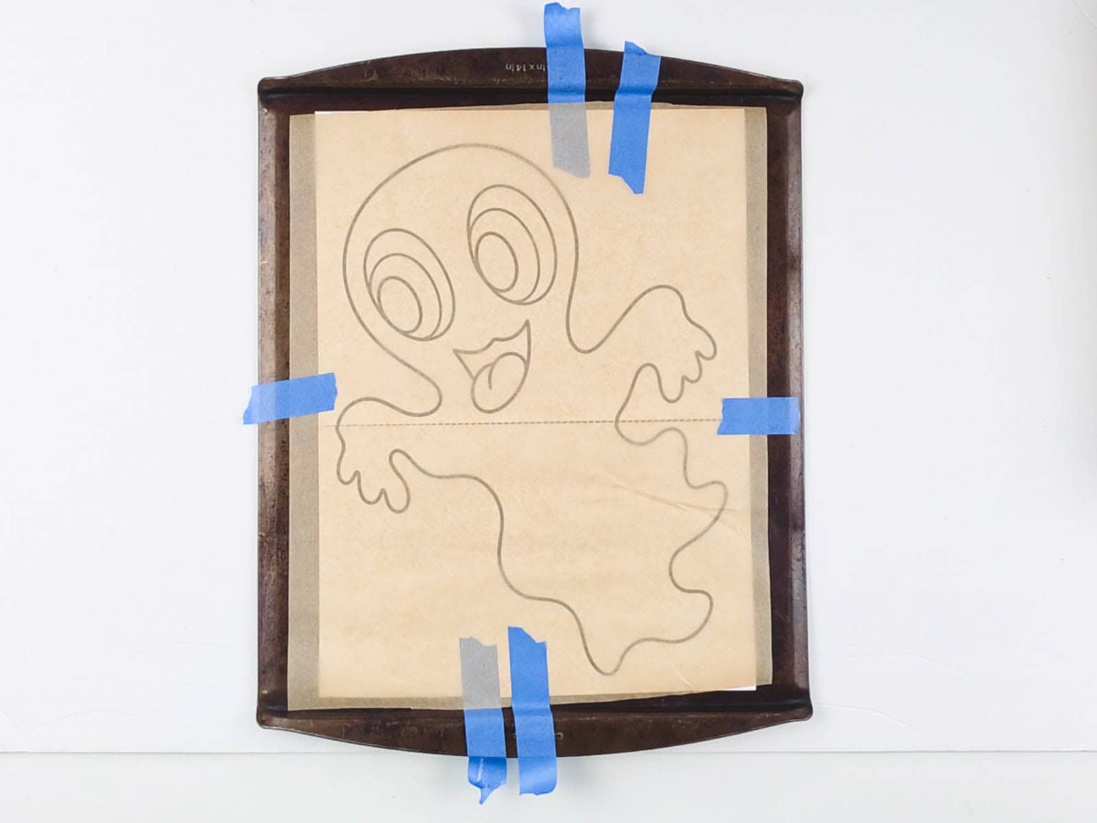 Halloween decoration paper pattern covered with parchment paper on a baking sheet